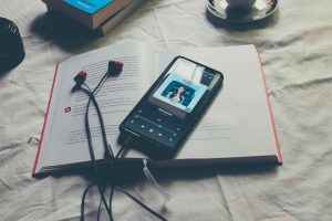 cellulare appoggiato su libro con musica in streaming