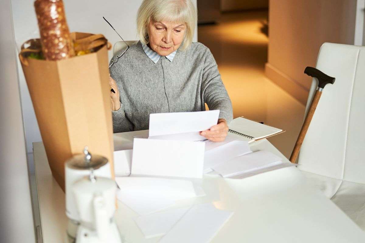 Donna al tavolo che controlla la proprio pensione